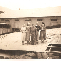 Retrato grupal de un grupo de personas posando sobre los restos de una construcción destruida por el terremoto de 1936